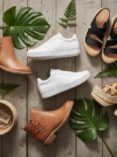 Variedad de calzado vegano sostenible, incluyendo zapatillas y botas, fabricado con materiales ecológicos.