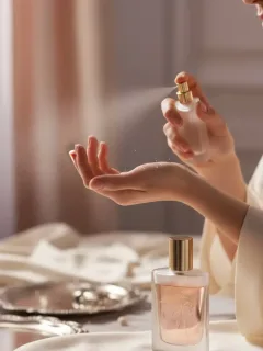 Mujer aplicando perfume en la muñeca para aumentar su duración