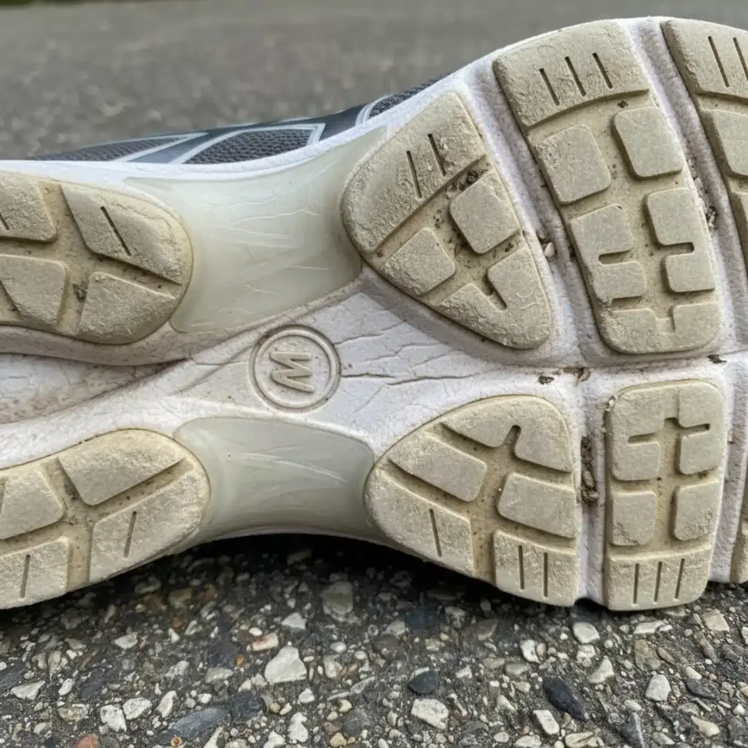 Suela de zapatilla de correr con desgaste irregular y amortiguación comprimida.