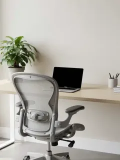 Oficina en casa moderna y organizada con luz natural y silla ergonómica