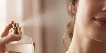 Mujer aplicando perfume en el cuello, destacando la elegancia en la rutina de belleza.