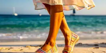 Mujer elegante con alpargatas en la playa, disfrutando del sol y el mar en verano de 2026. Alpargatas en 2026.