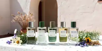 Frascos de perfume sostenible elaborados con materiales reciclados y esencias naturales, en un entorno elegante y ecológico.